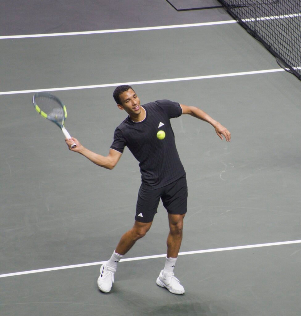 Félix Auger-Aliassime sends tennis balls to the crowd after his win over Alexei Popyrin at Rotterdam 2026.