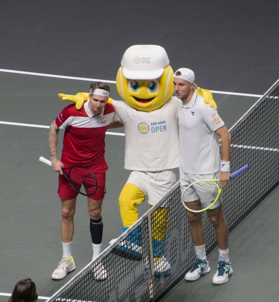 Jan-Lennard Struff and Alexander Bublik pose with the tournament mascot before their Round of 16 match at the ABN AMRO Open in Rotterdam 2026.