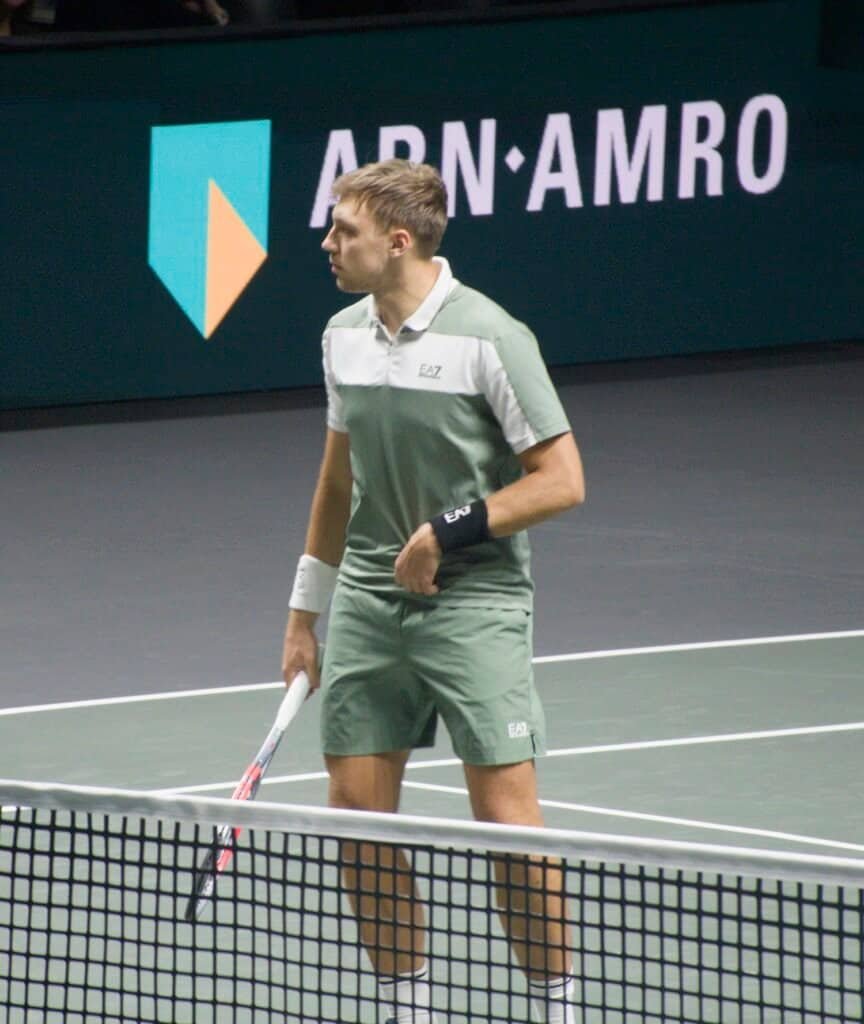 Hamad Medjedovic in green kit ready to serve during R16 match against Felix Auger-Aliassime at ABN AMRO Open 2026 Rotterdam ATP 500.