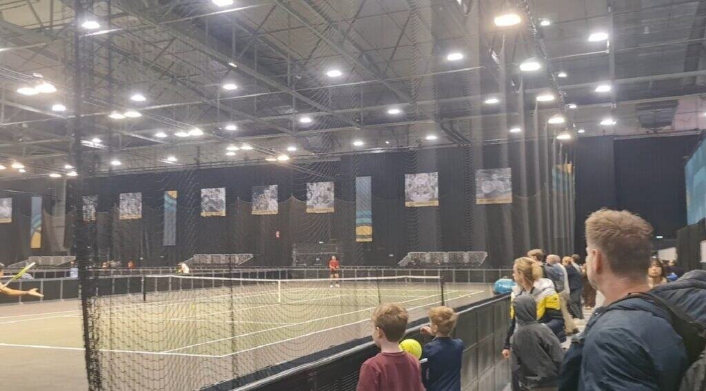 Fans watching players on practice courts inside Rotterdam Ahoy on Day 2 of the ABN AMRO Open 2026 ATP 500 (De Minaur & Medjedovic action).