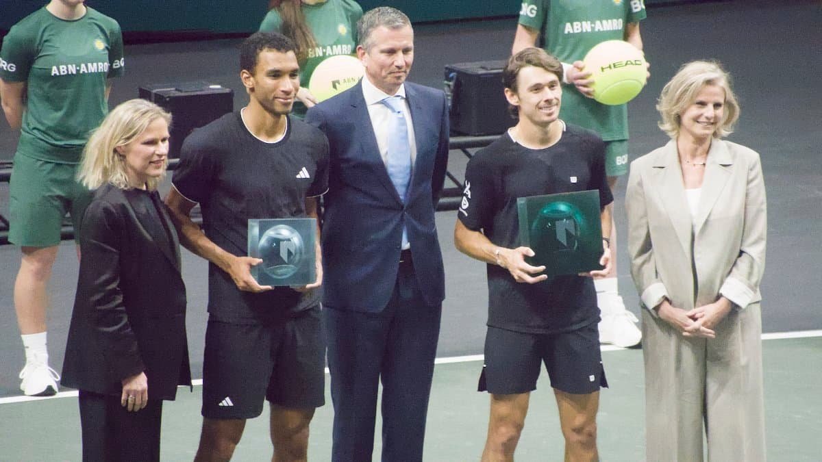 Félix Auger-Aliassime (left) and Alex de Minaur (right) receive trophies at the ABN AMRO Open 2026 final ceremony.