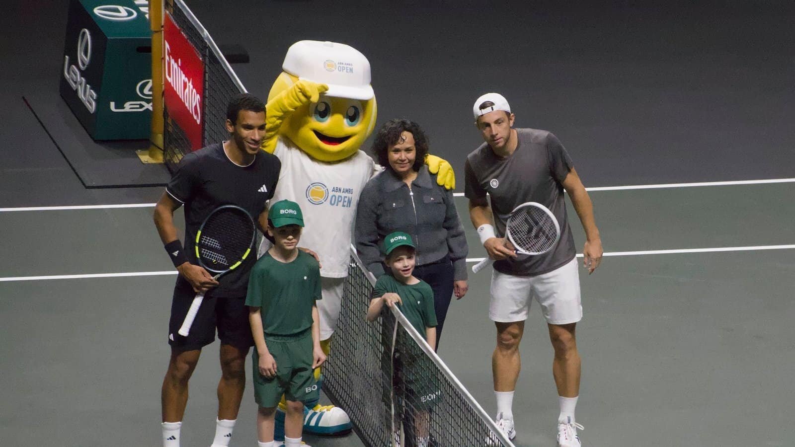 Tallon Griekspoor and Félix Auger-Aliassime pose at the net with the ABN AMRO Open mascot and ball kids before their quarter-final in Rotterdam 2026.