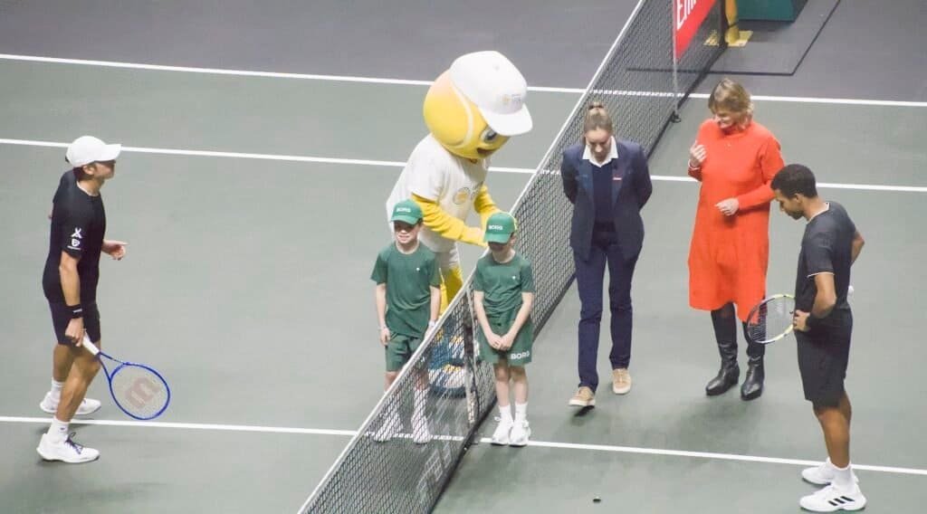 Tournament mascot with kids and family join players for net-post ceremony at Rotterdam ATP 500 2026 final.