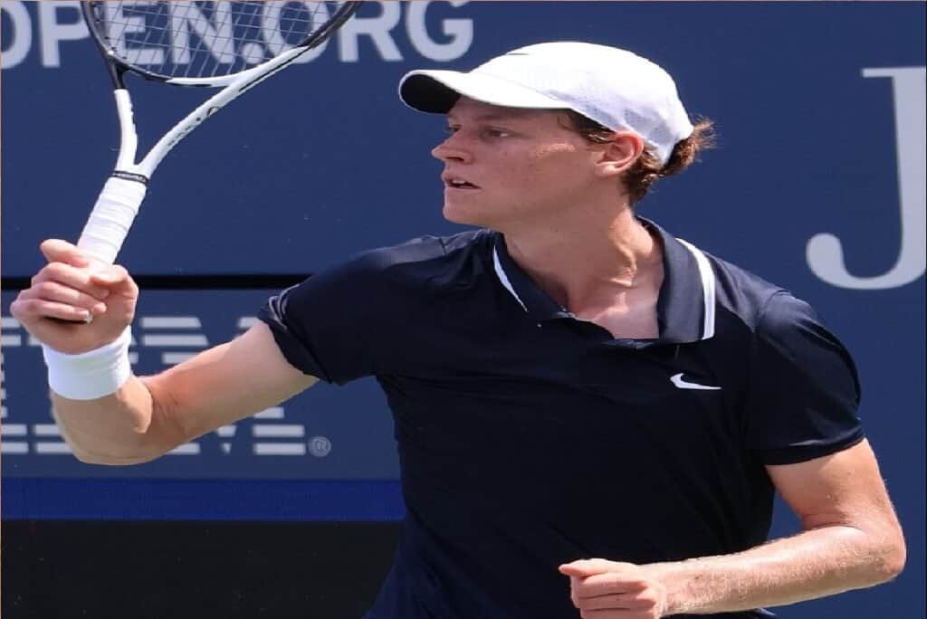 Jannik Sinner with a clenched fist celebrating a point on the court