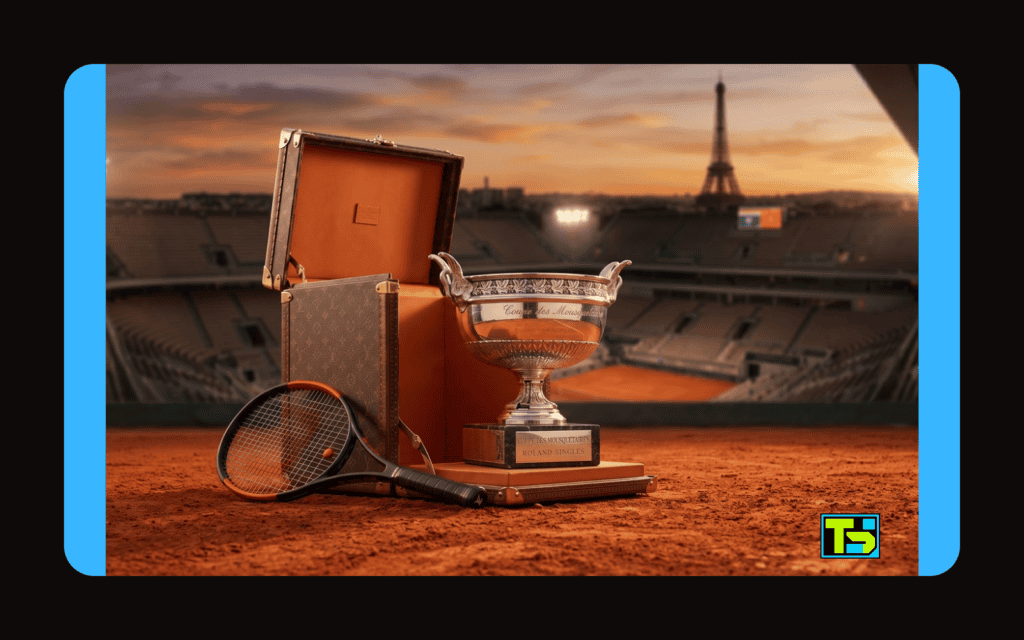 Krupni plan trofeja Kup musketara na crvenoj šljaci, koji izlazi iz otvorenog Louis Vuitton kofera sa stadionom i Ajfelovim tornjem u pozadini.