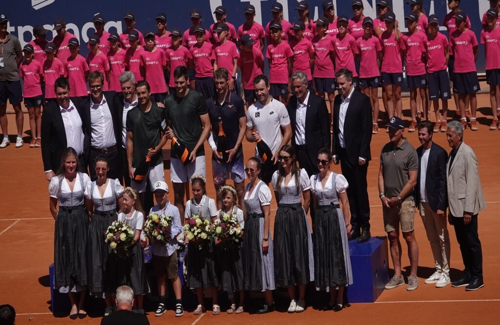 Doubles finalists and organizers celebrating on the podium at the 2026 Generali Open in Kitzbuhel