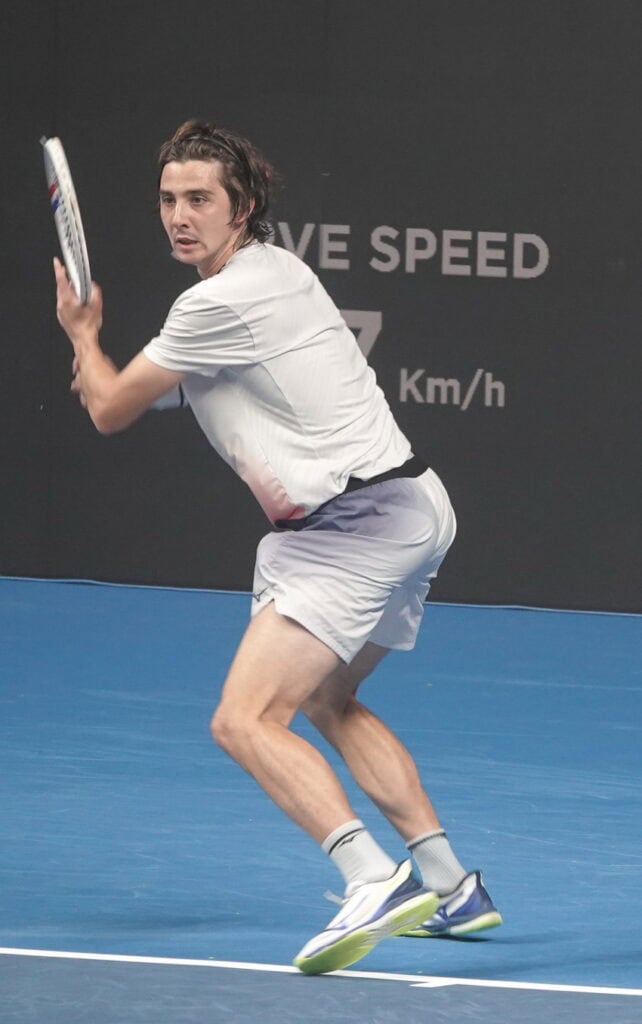 Tennis player Aleksandr Shevchenko preparing for a backhand shot during a match at the Almaty Open tournament.