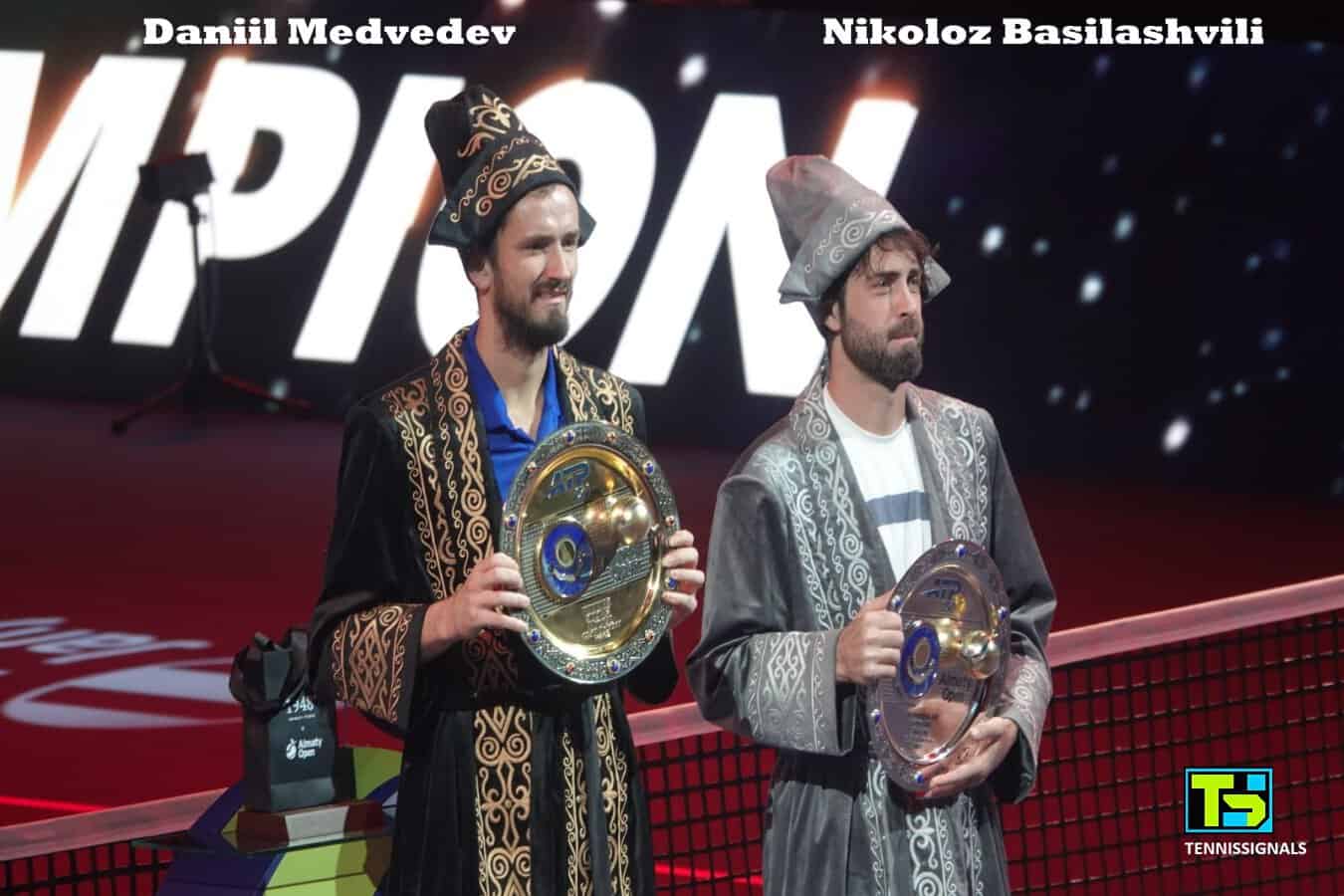 Daniil Medvedev and Nikoloz Basilashvili posing with their trophies in traditional Kazakh clothing after the ATP Almaty final.