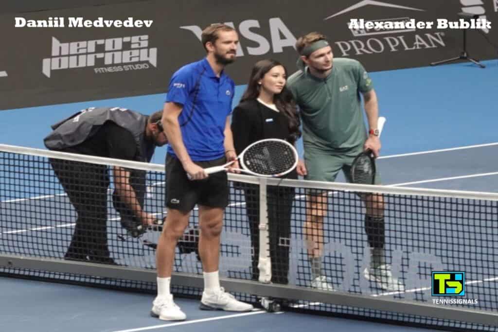 Daniil Medvedev and Alexander Bublik standing at the net with the umpire before the start of their semifinal match at the Almaty tournament.